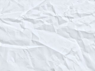 Crumpled white paper texture featuring light creases and gentle shadows. White paper background with soft wrinkles and subtle folds.