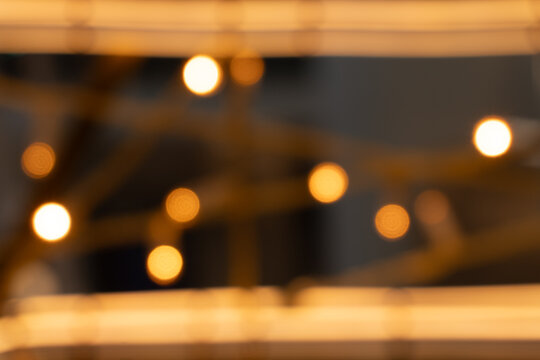 Warm yellow bokeh lights strung in horizontal lines, abstract festive glow against dark background