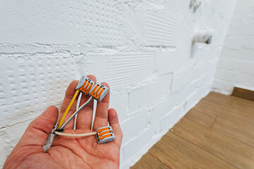 connector setup scene, electrical connectors being carefully positioned against brick wall, realistic scene of technician arranging electrical connectors with precise focus on placement details