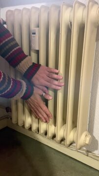 Manos calientes en la calefacci&oacute;n de casa en invierno