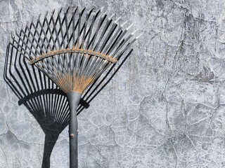 A black steel rake leaned against the wall