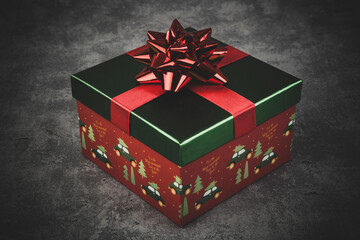 Christmas shiny gift box with a bow on a rustic background