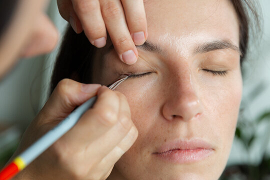 Makeup artist working on woman during beauty session. Concept of personal care, creative process and enhancement of individual style.