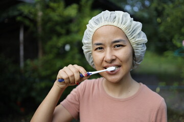 woman brushing her teeth in the morning.