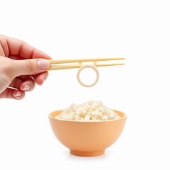 Hand holding training chopsticks with ring over a small bowl of cooked white rice isolated on white background