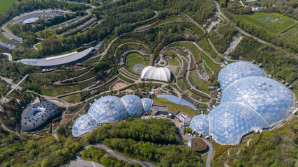 Aerial view of the biomes, glass structures, and lush gardens of the Eden Project blending with the natural landscape, Eden Project, Cornwall, United Kingdom.
