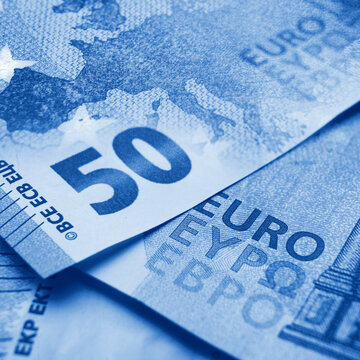 Closeup view and shallow focus  of 50 euro bills with europe map toned in blue