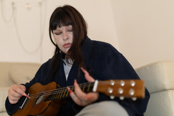 Young musician playing acoustic guitar contemplating music