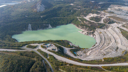 Aerial view of a serene, milky green lake nestled amidst the stark white contours of the Clay Works, a study in contrasts between nature and industry, Clay Works, Saint Austell, United Kingdom.