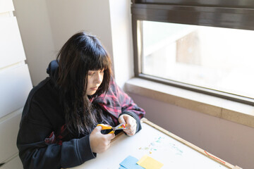 Young person enjoying paper crafting hobby at home