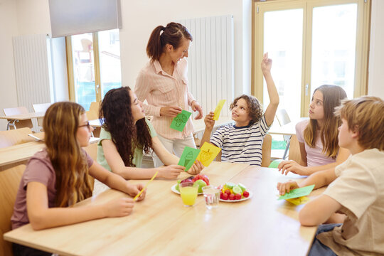 Teacher discussing healthy food choices with students in a school cafeteria