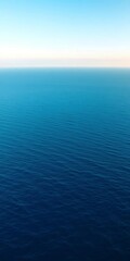 Fototapeta premium Vast expanse of calm, deep blue ocean stretching to the horizon under a clear sky, sea, ocean
