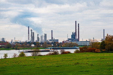 Fototapeta premium Atmospheric skies over industrial buildings on the Rhine in Germany.