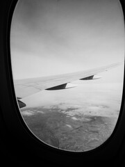 Aile d'un avion volant au-dessus des nuages. Noir et blanc.
