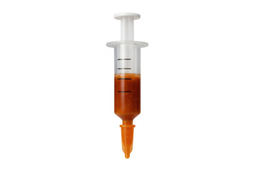 Food injector syringe filled with orange liquid for cooking
