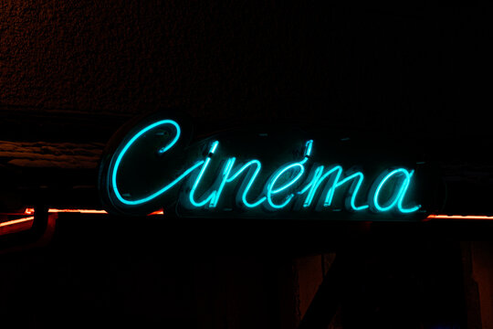 Neon cinema sign glowing at night