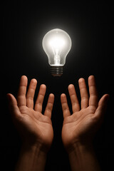 both hands holding the shining light bulb