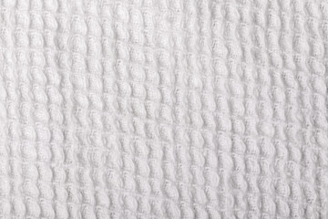 Close up of white waffle weave fabric texture, ideal for backgrounds, textile design, or product presentations.