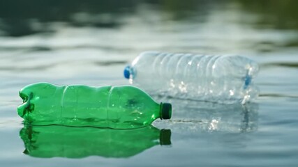 Plastic bottles floating and rotating on water surface with green transparent reflection, highlighting environmental pollution, waste impact, and aquatic ecosystem nature conservation efforts