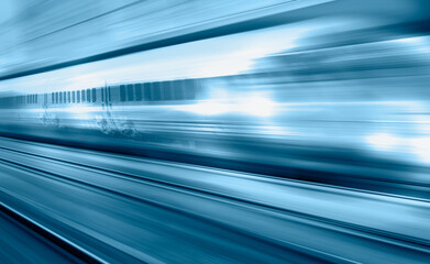 Blue high speed train runs on rail tracks - The train is going too fast as a result the air pressure is causing too much heat at the front