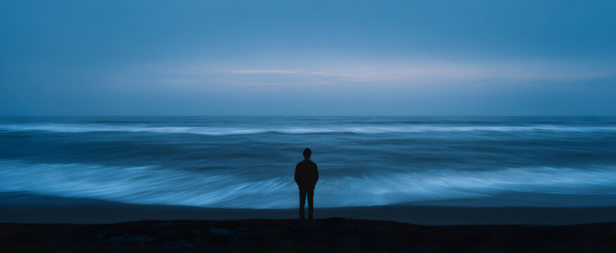 A lone figure feels deep solitude gazing at the endless ocean at twilight