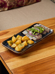 seafood with herbs, homestyle seafood presentation featuring herring with roasted vegetables and herbs