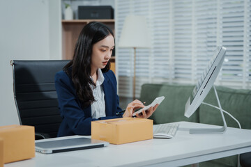Asian female entrepreneurs coordinating product handover at an e-commerce office, preparing parcels for shipping logistics while collaborating professionally to manage online business operations