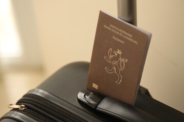 Luxembourg passport on touristic baggage luggage in airport close up. Travel and tourism in Europe concept
