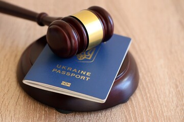 Judge mallet and ukrainian passport on brown background. Passport Of Ukraine. Obtain citizenship
