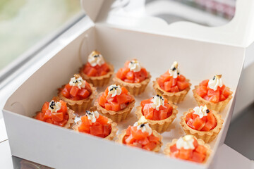 Salmon tartare tartlets with cream cheese in delivery box