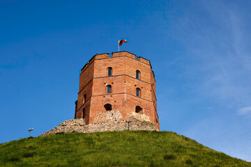 Historical red brick Gediminas tower on Castle Hill, a symbol of Vilnius, Lithuania's capital city, against a clear blue sky. Cultural heritage site, monument in the Baltic States, Eastern Europe