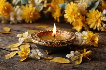 Diwali Celebration - Lit Diya with Flowers on Wooden Surface.
