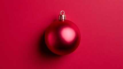 A shiny red ornament sits on a rich crimson surface, capturing the essence of holiday joy and warmth as the festive season approaches, evoking nostalgia and cheer