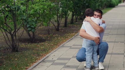 Boy hugging father, child running to father to cuddle outdoors, childhood dream, father's day, man hugging boy son in the park, happy family in the park, little kid with parent, concept happy family