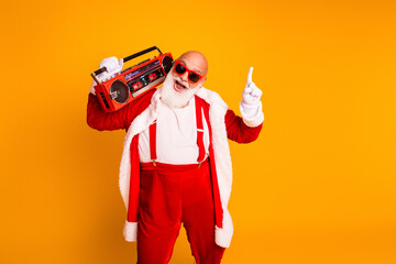 Festive Santa with red suit and boombox enjoying christmas party and music set against bright yellow background