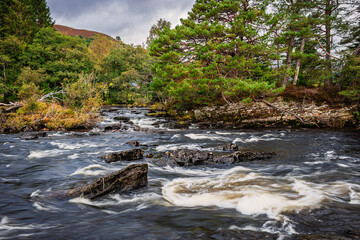 Island in the river at The Falls of Dochart, which are a series of rapids on the River Dochart in the village of Killin, Scotland, in the Trossachs National Park