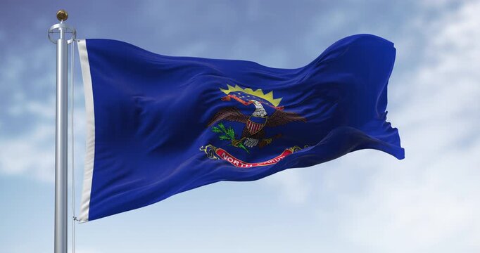 North Dakota state flag waving in the wind on a clear day