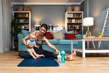 Young mother practicing yoga at home with baby nearby balancing postpartum recovery mindfulness gentle movement during evening workout joy family bonding on mat calm wellness routine for active parent