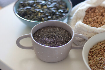 Bowls and bags full of various healthy grains and legumes. Selective focus.