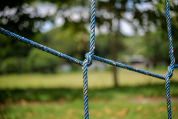 Closeup of blue ropes tied in a knot at a park playground setting