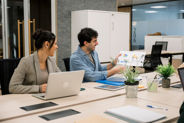 Business colleagues collaborating on report in modern office