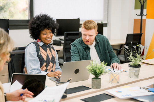 Diverse colleagues collaborating and working together in modern office - Powered by Adobe