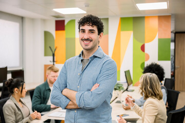 Confident businessman smiling arms crossed in office meeting