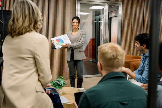 Businesswoman presenting pie chart during office meeting