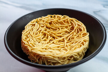 Instant ramen is a round, dry, uncooked instant noodle.
