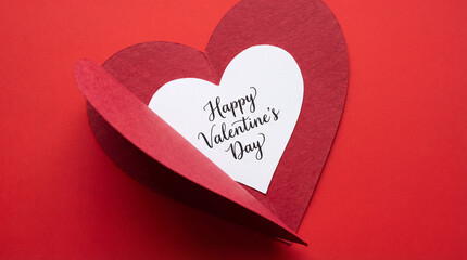 Romantic close-up of an open red heart-shaped Valentine’s Day card revealing a handwritten love message inside.
