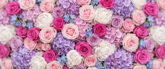 Vibrant floral background featuring a lush mix of roses in soft pink, purple, and white tones.