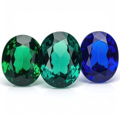 Fototapeta premium Three round faceted gemstones, emerald green, teal green, and sapphire blue, are displayed in a studio shot
