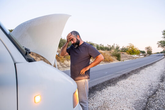 Man experiencing frustration with broken down van on roadside
