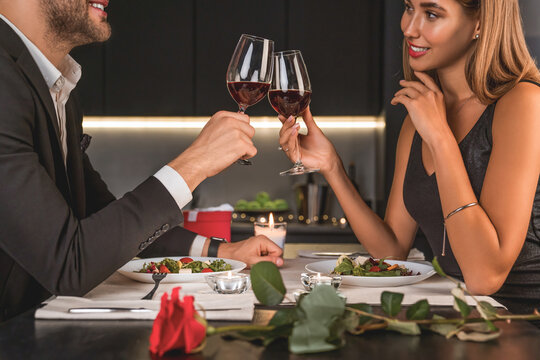 Happy couple toasting wineglasses at home kitchen. Special event celebration. Anniversary, proposal, engagement, Valentine`s day, birthday, dating - Powered by Adobe